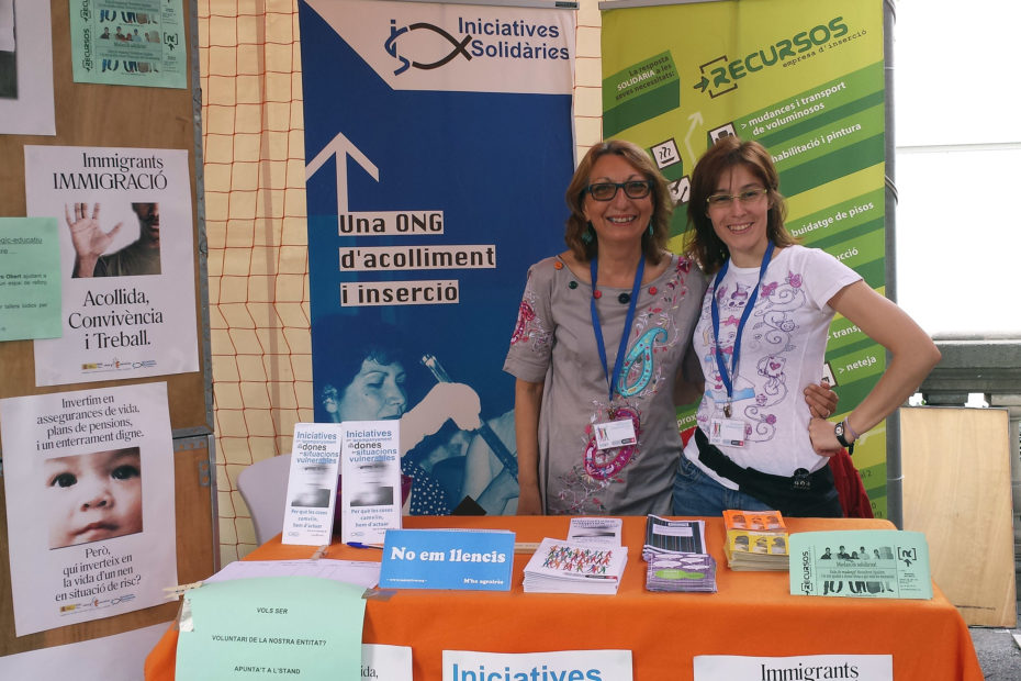 Dues treballadores a càrrec de l'estand d'Iniciatives Solidàries a la Plaça Catalunya.